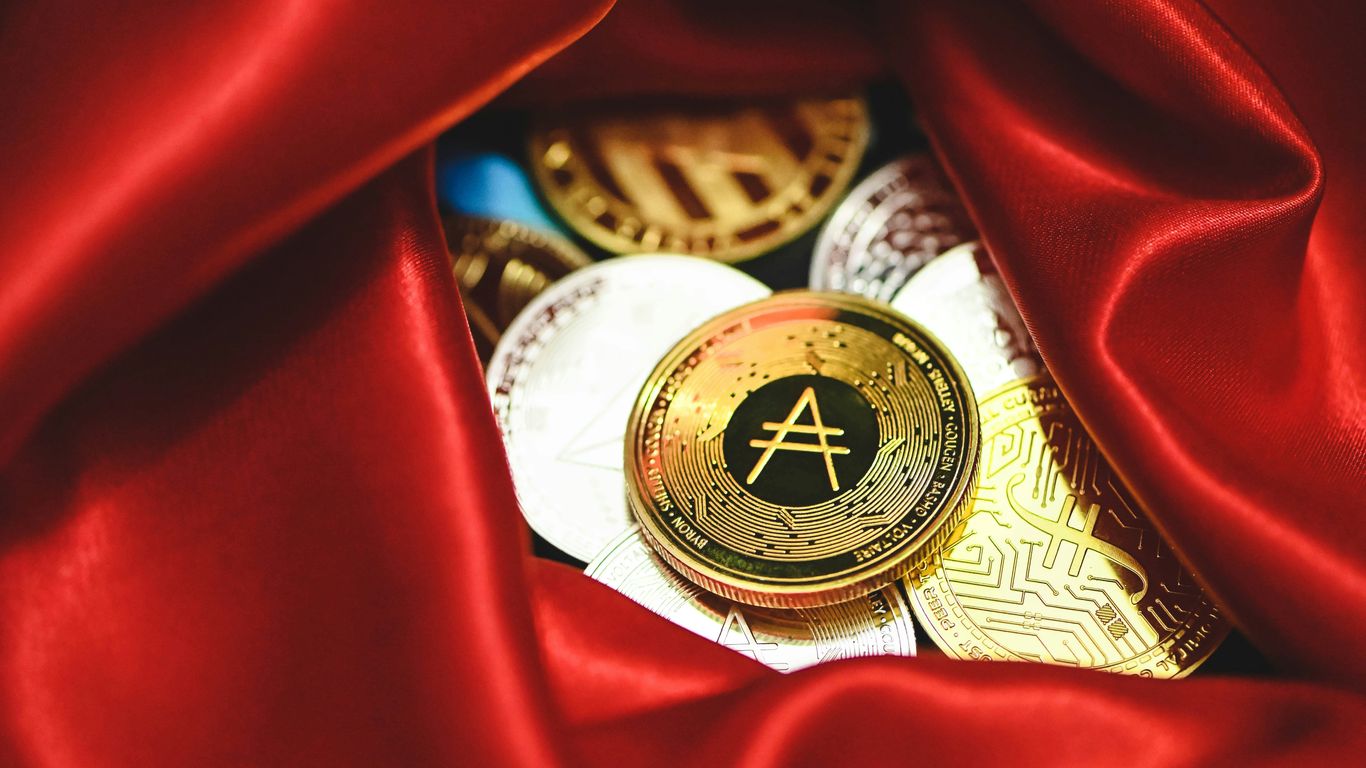 a pile of gold and silver coins sitting on top of a red cloth