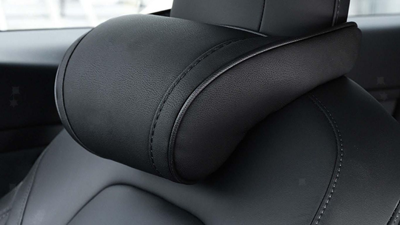 Black leather car headrest positioned on a sleek seat.