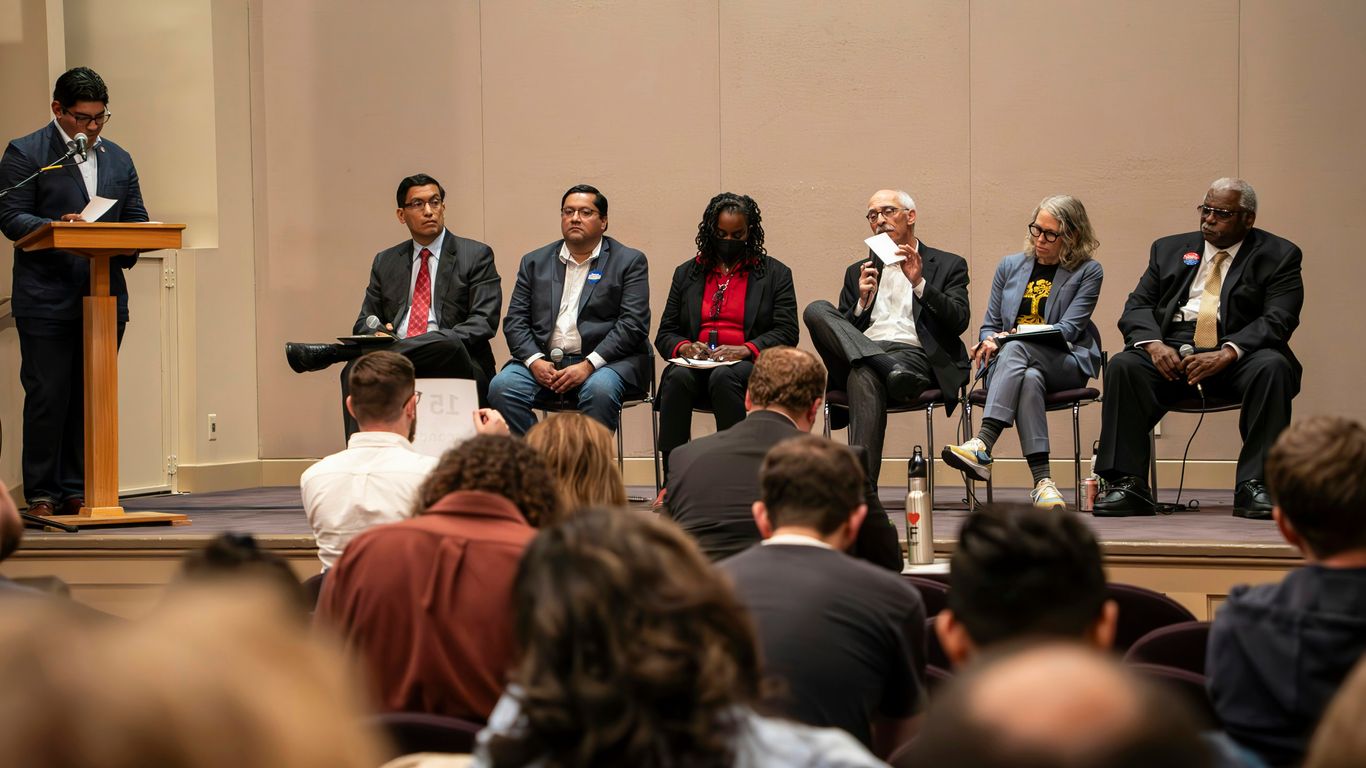 A group of people sitting on a stage in front of a crowd