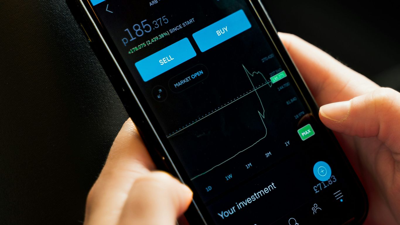 A person checking investment details on a smartphone app.