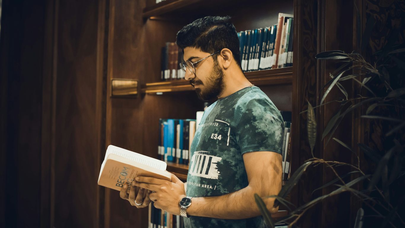 a man reading a book in a library