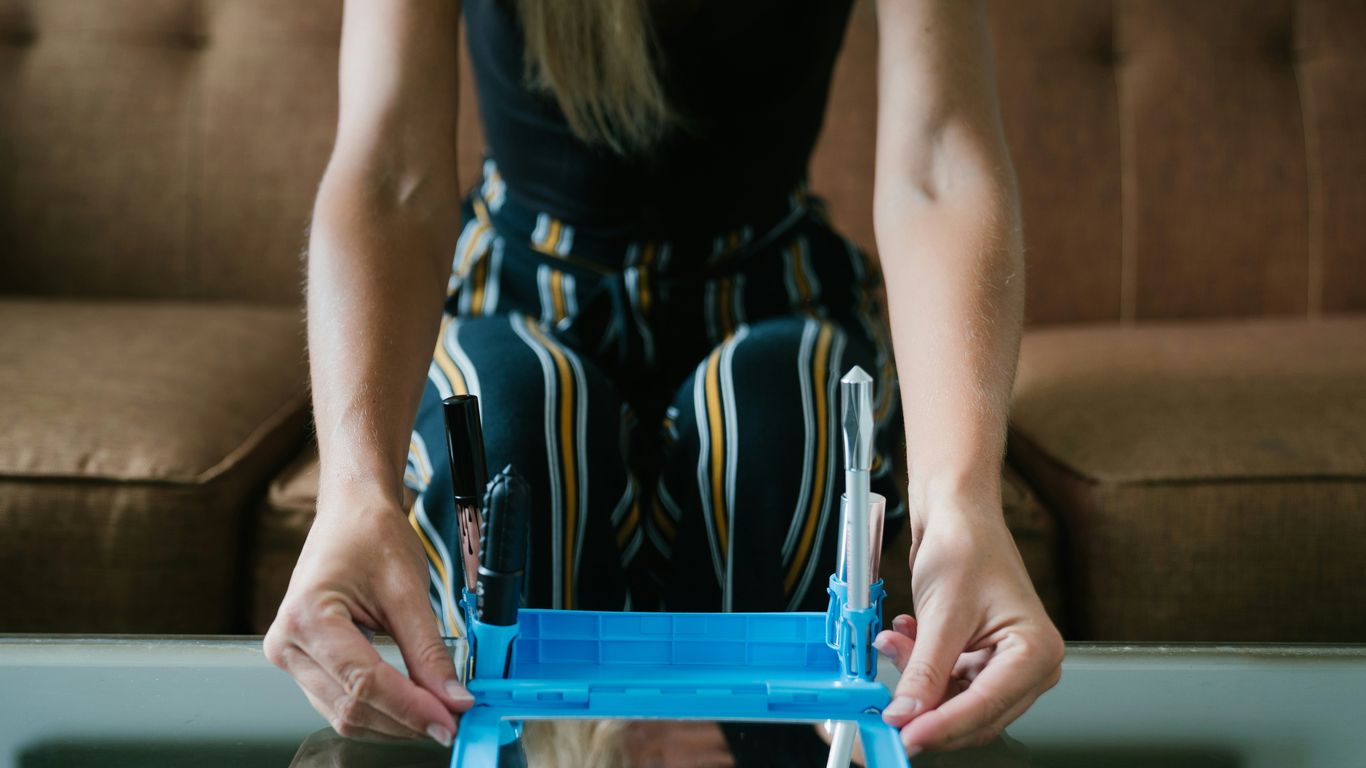 woman in black and white sleeveless dress sitting on blue chair