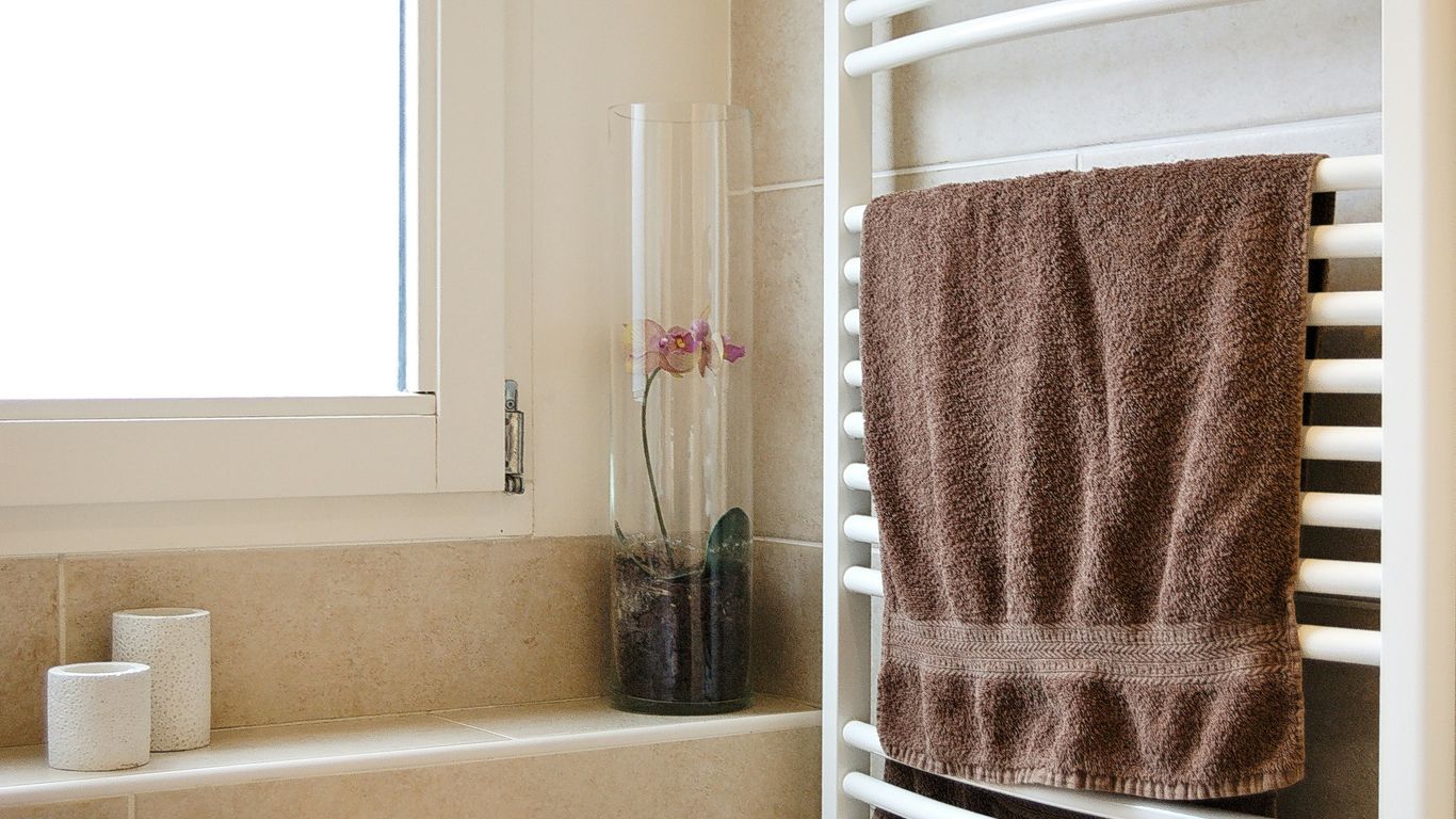 pink towel on white metal rack
