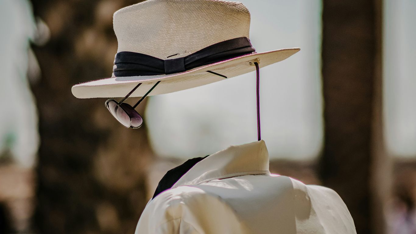 person wearing white dress shirt and brown fedora hat