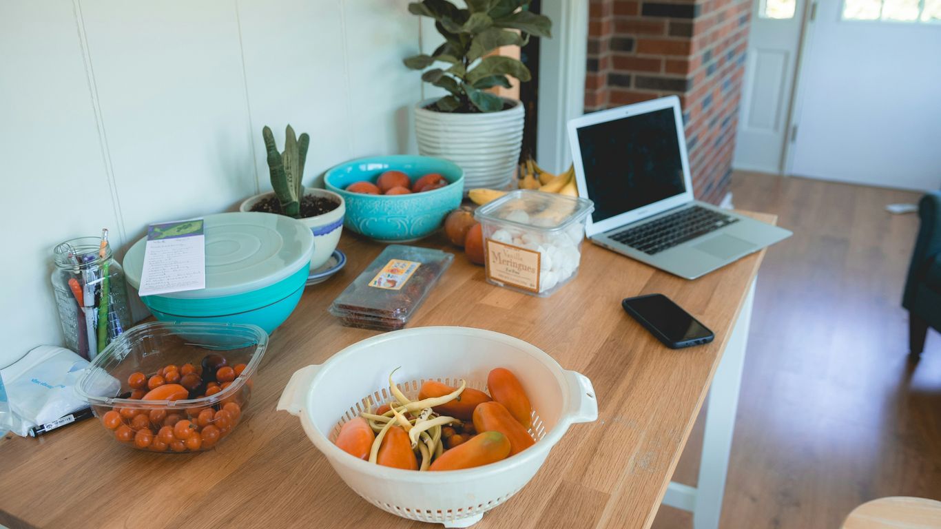 orange fruits in white basket on top of brown table
