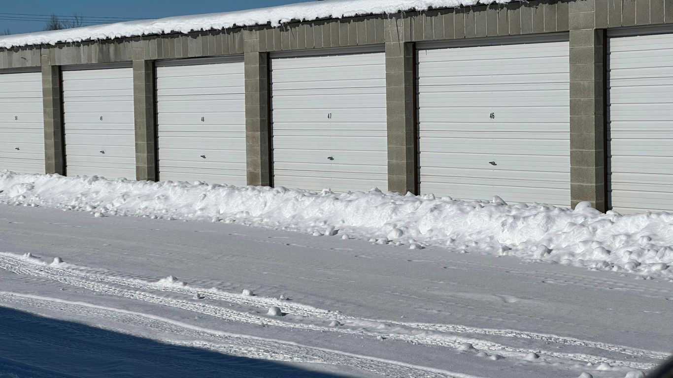 a row of garages with snow on the ground