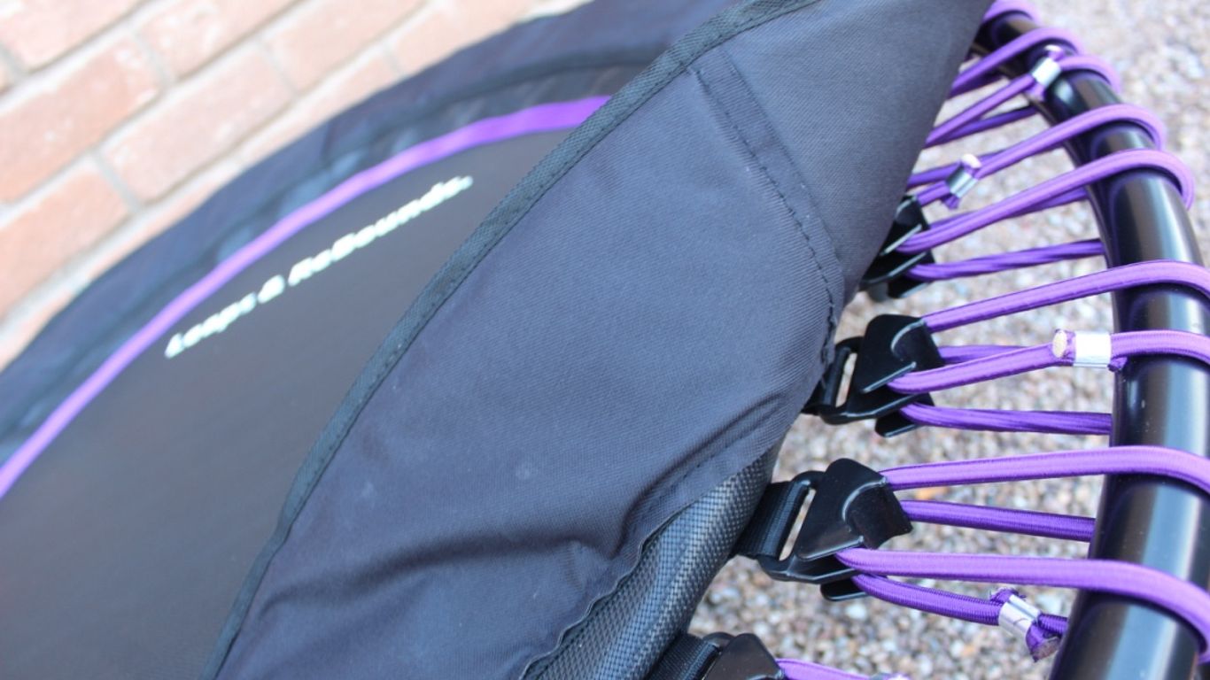 Close-up of a mini trampoline with purple bungee cords.