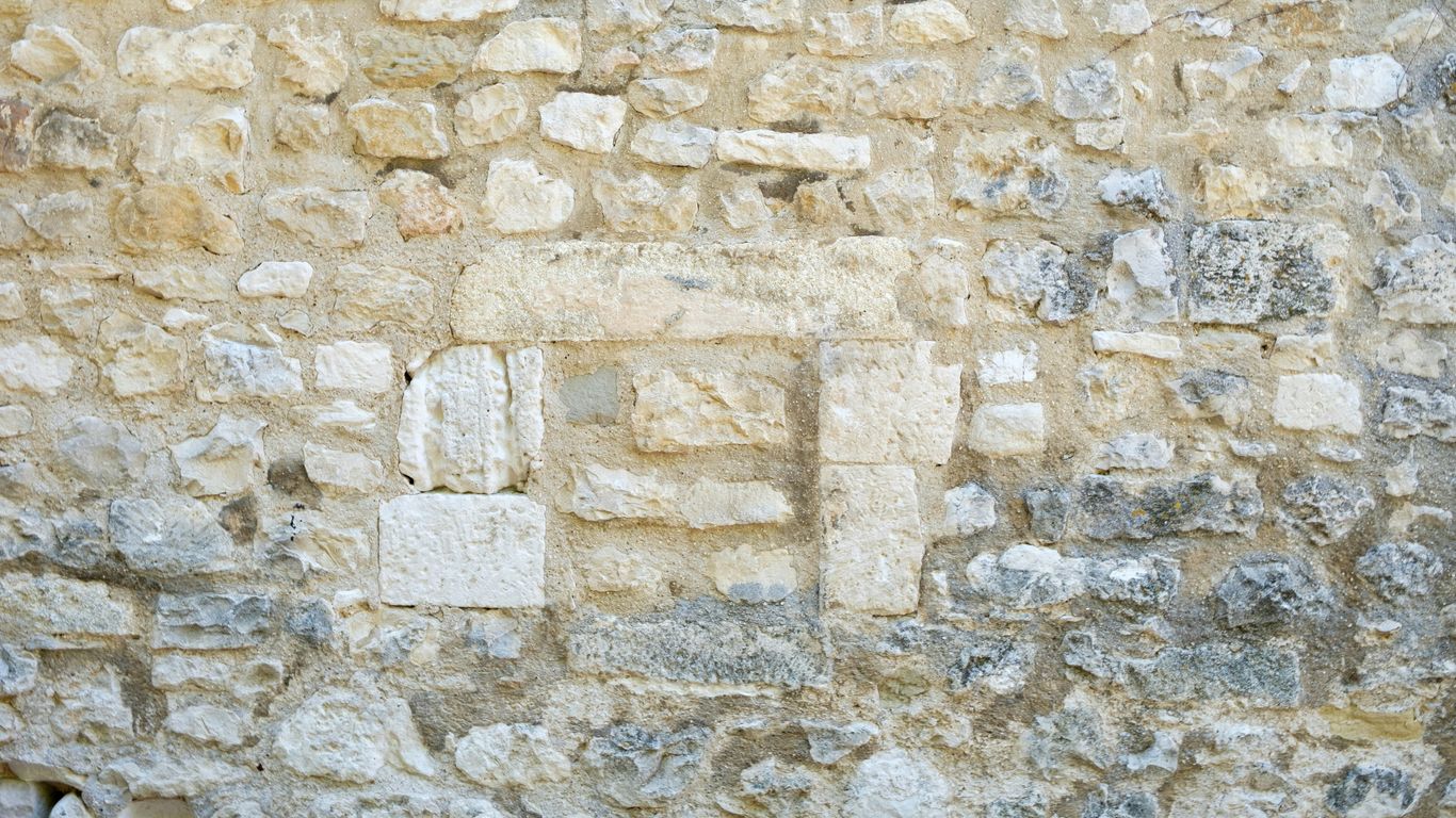 a stone wall with a clock on it