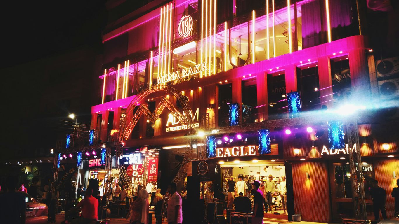 a group of people standing outside of a building at night