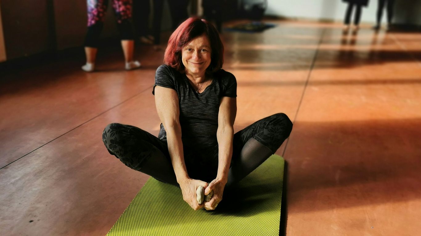 woman in black tank top and black pants lying on green mat