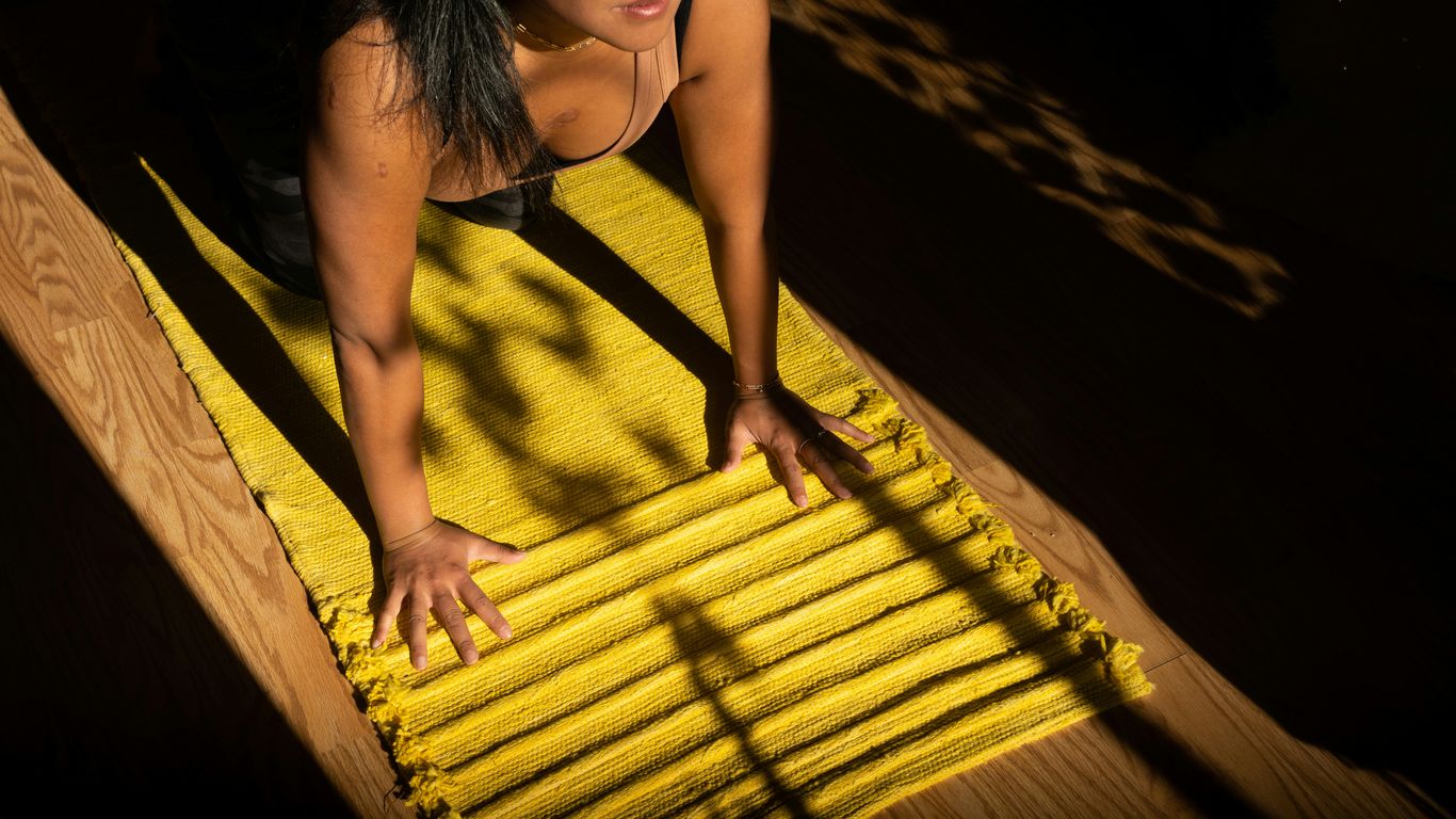 woman in yellow tank top standing on brown wooden dock during daytime