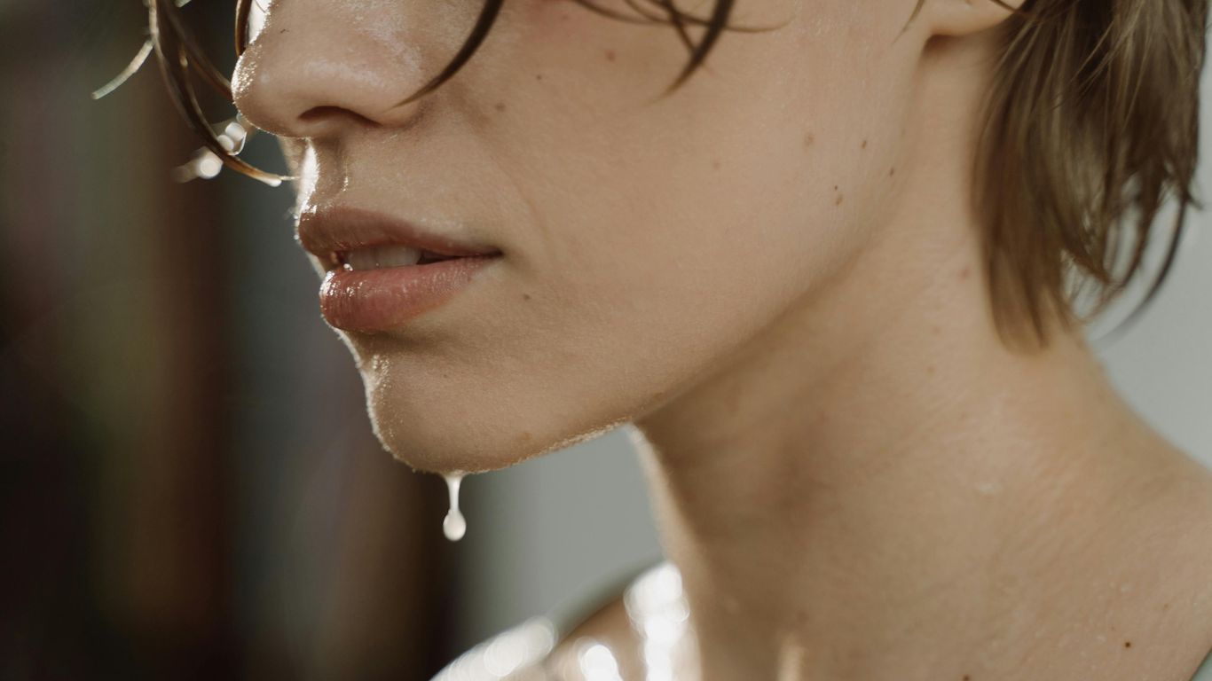 Close-up of person's wet face and chin, water dripping down.