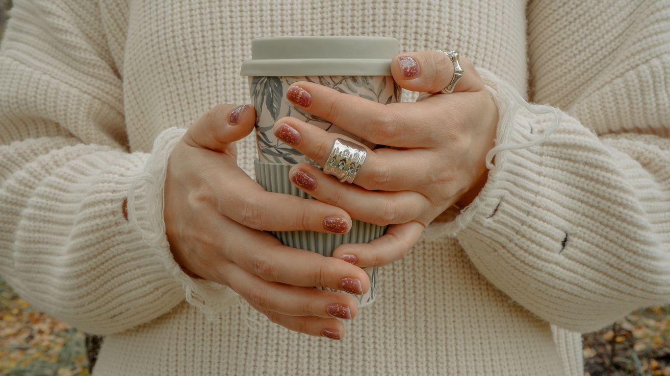 a woman holding a cup of coffee in her hands