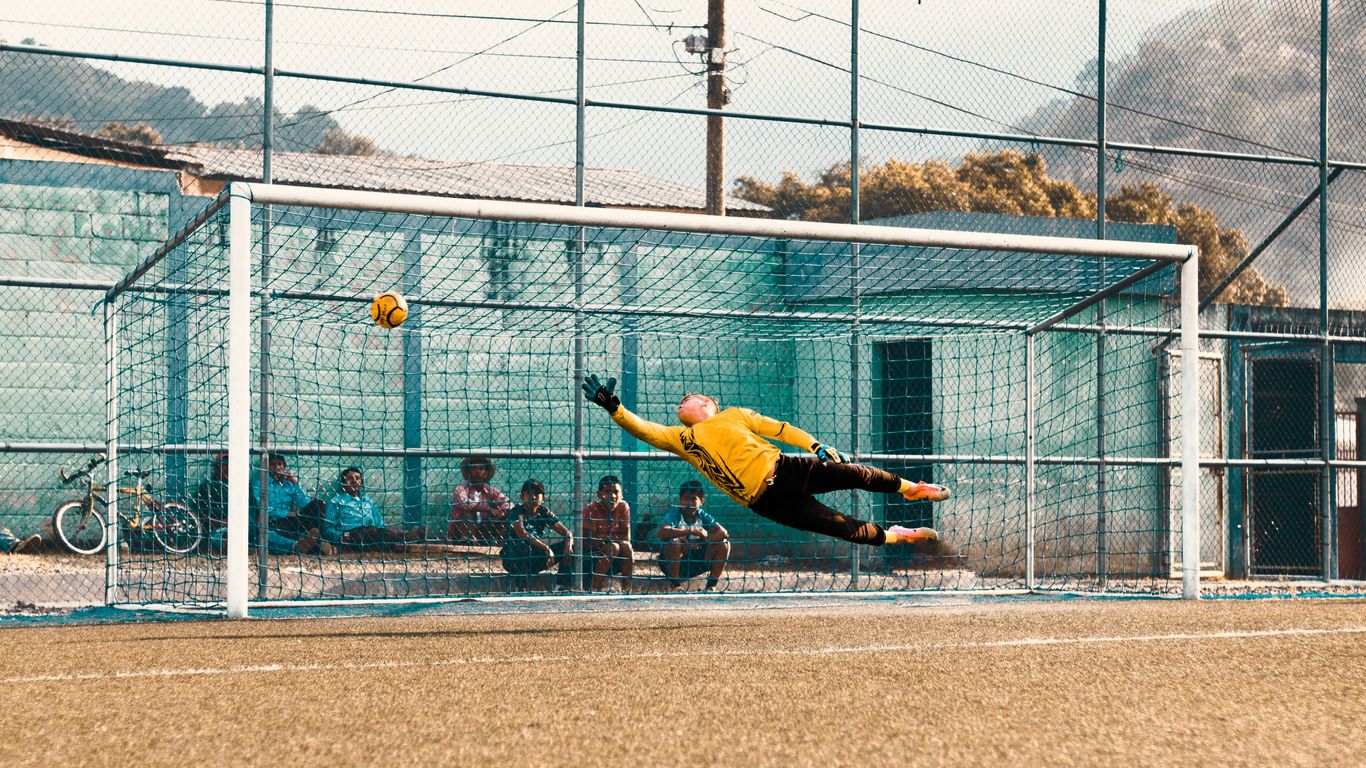 man jump about to hold ball near net
