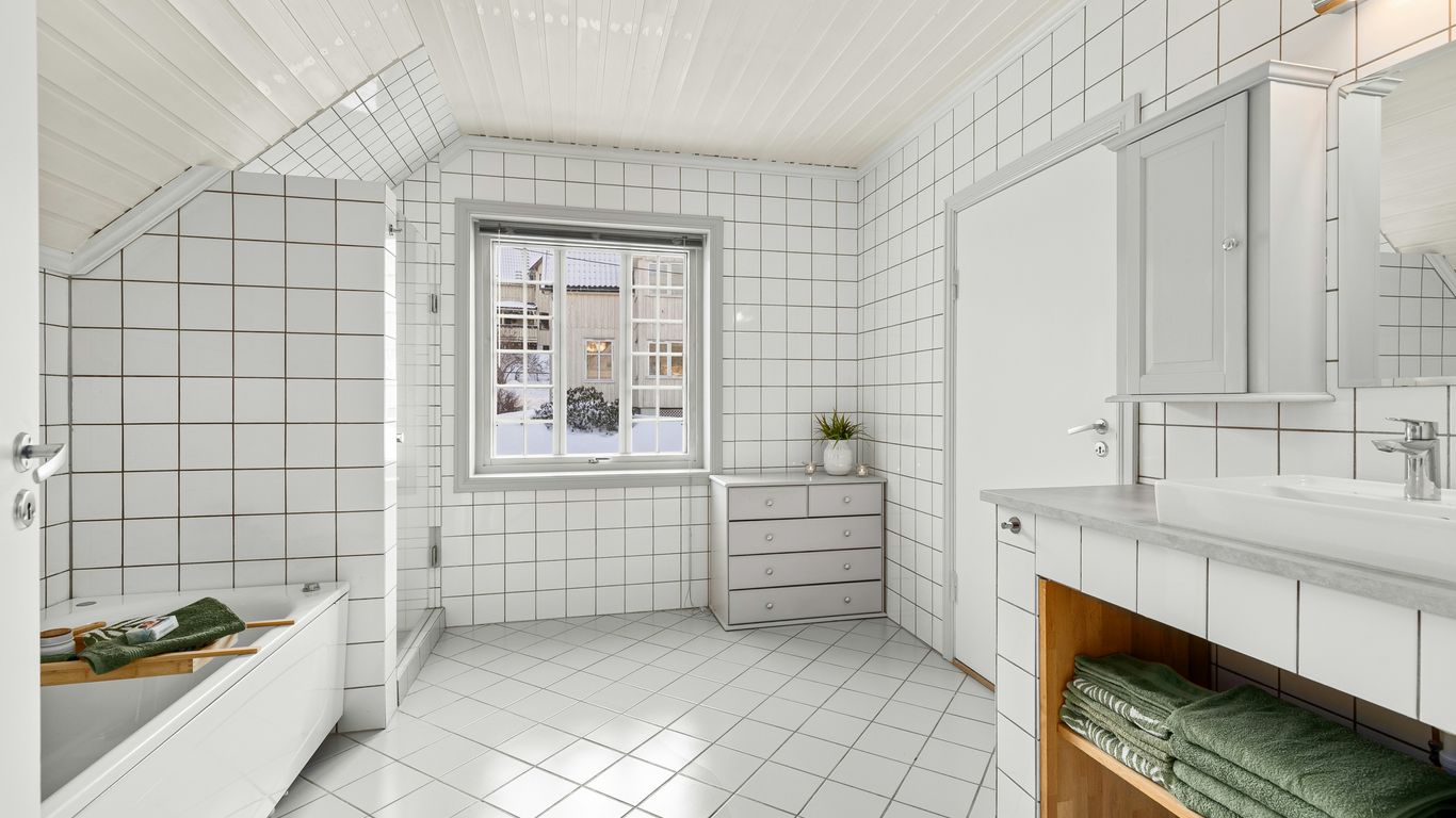 A bathroom with a tub, sink, and mirror