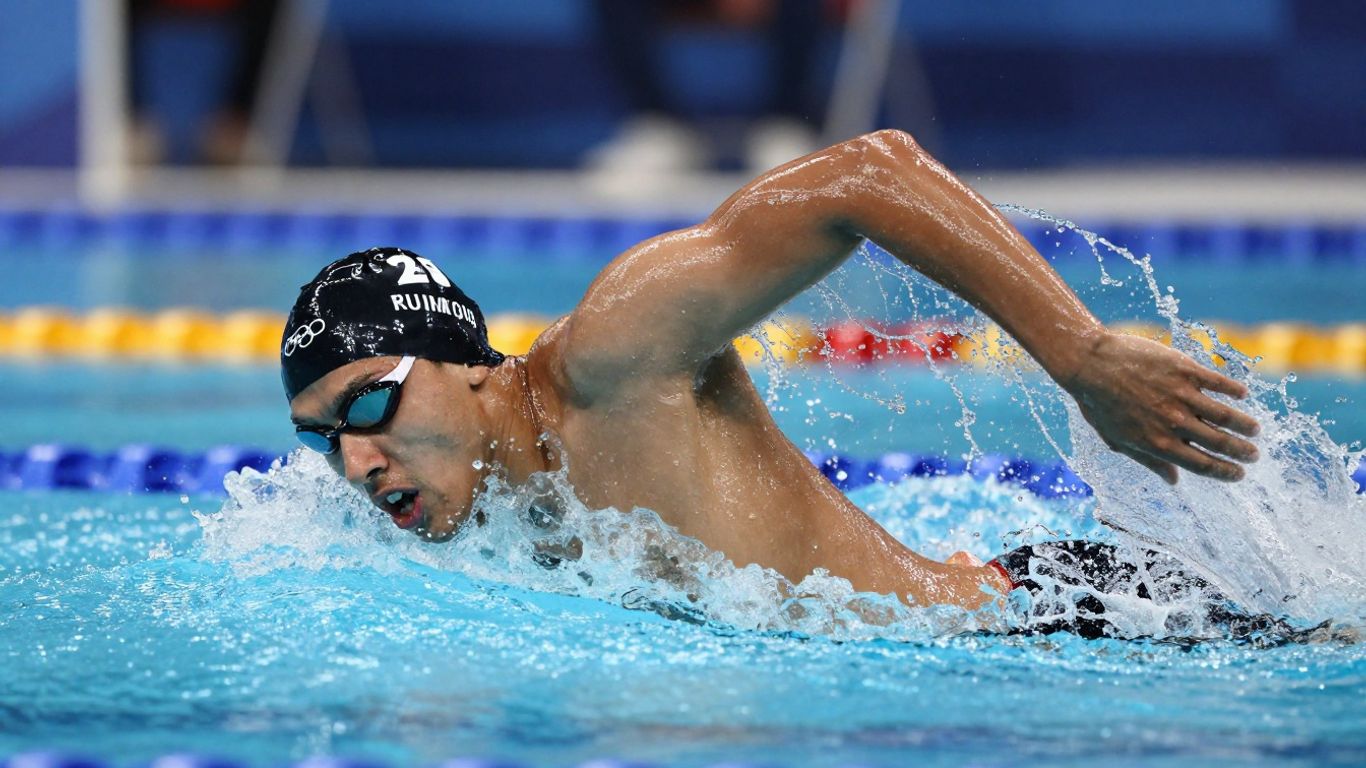 Înotător olimpic în acțiune, apă stropind.