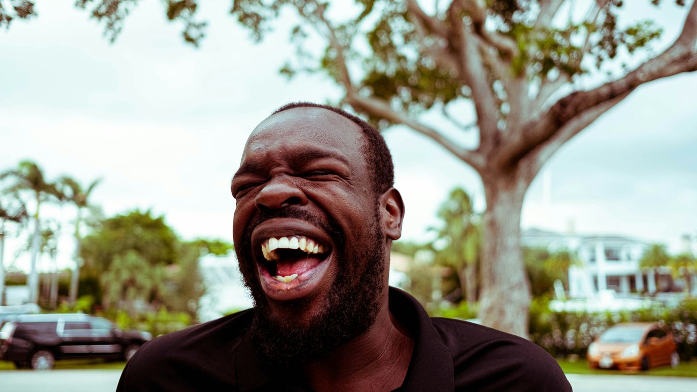 man in black polo shirt smiling