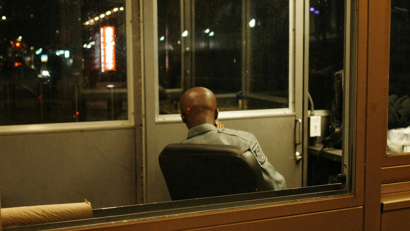 Man sitting in a security booth at night