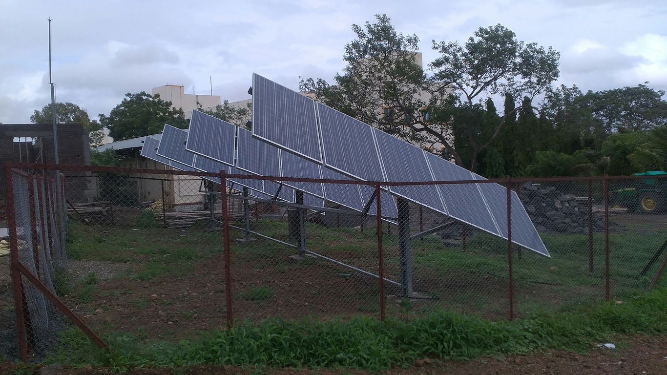 a fence with a bunch of solar panels on top of it