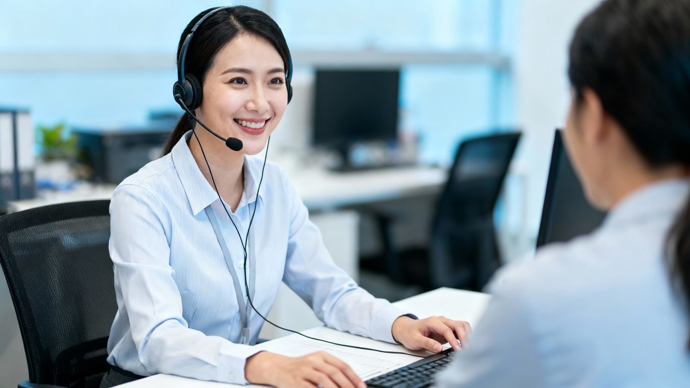 IT helpdesk technician assisting a client with a smile.
