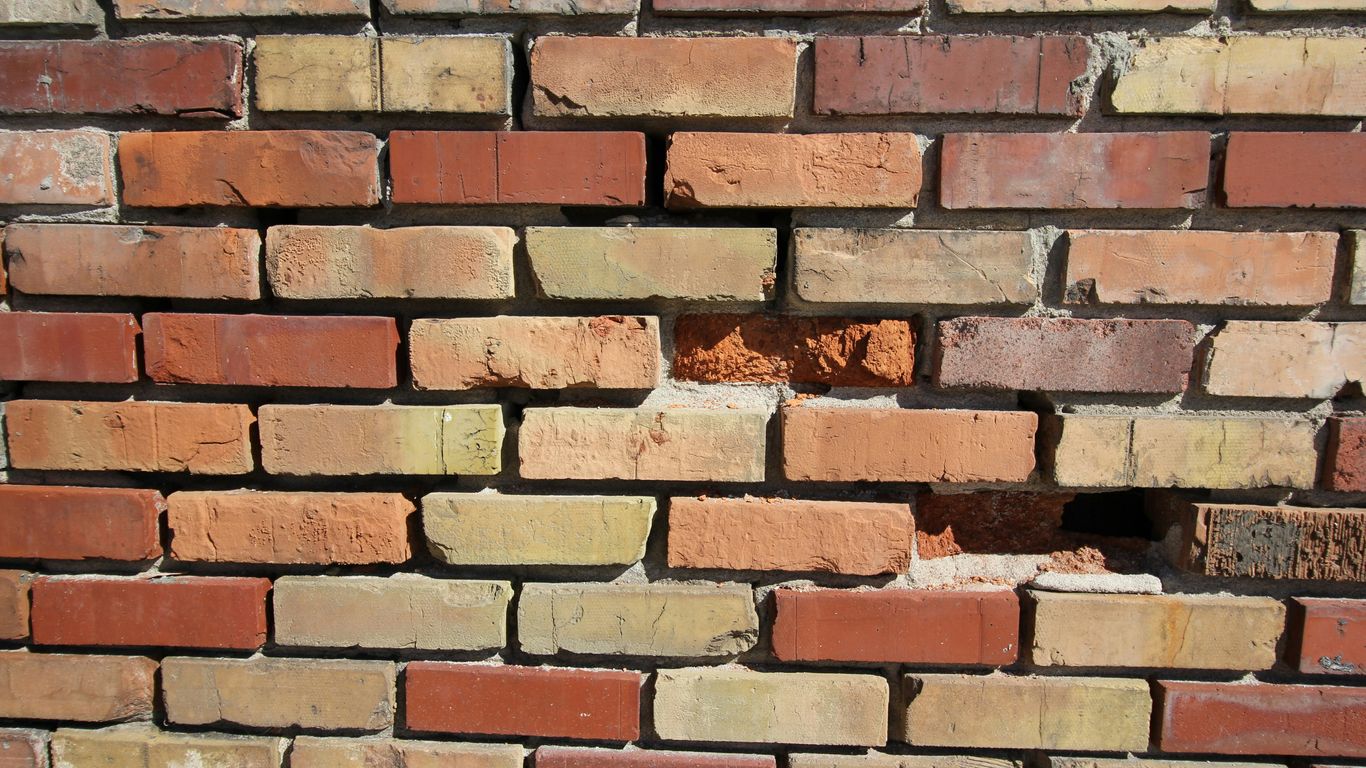 a close up of a brick wall with a hole in it