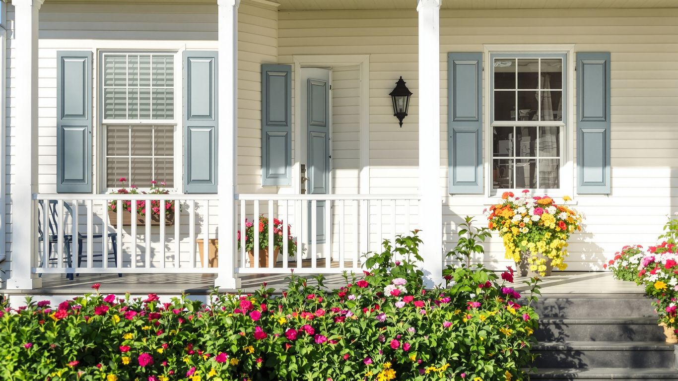 Updated house exterior with colorful flowers and clean siding.