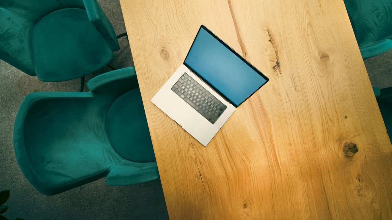A laptop computer sitting on top of a wooden table