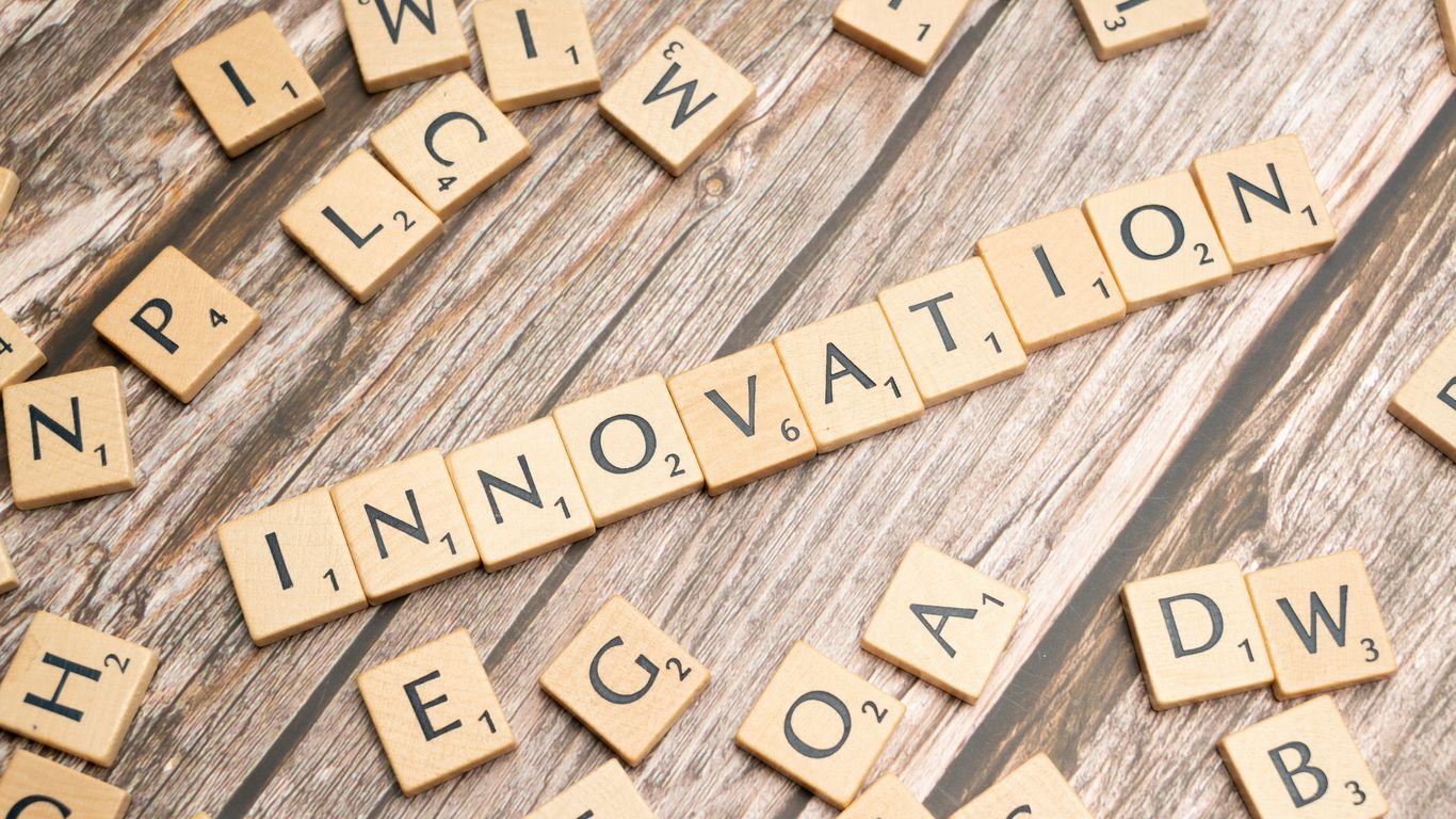 scrabble tiles spelling the word innovation on a wooden surface