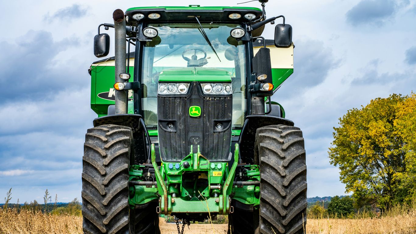 green and black tractor on brown grass field during daytime