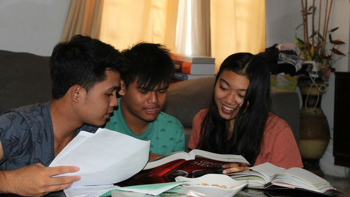 girl and two boys reading books