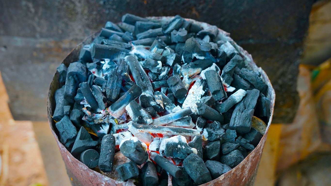 Burning charcoal inside of a metal container.