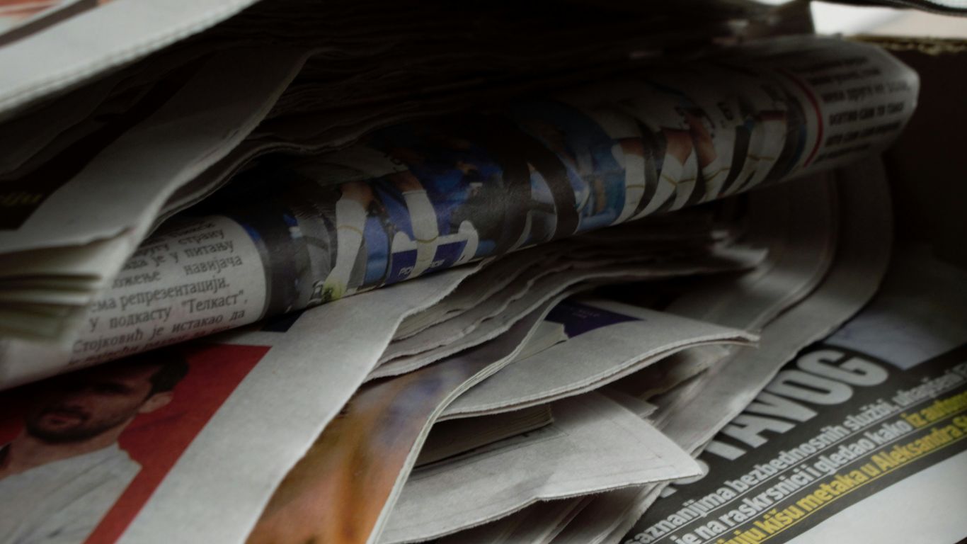 a bunch of newspapers stacked on top of each other