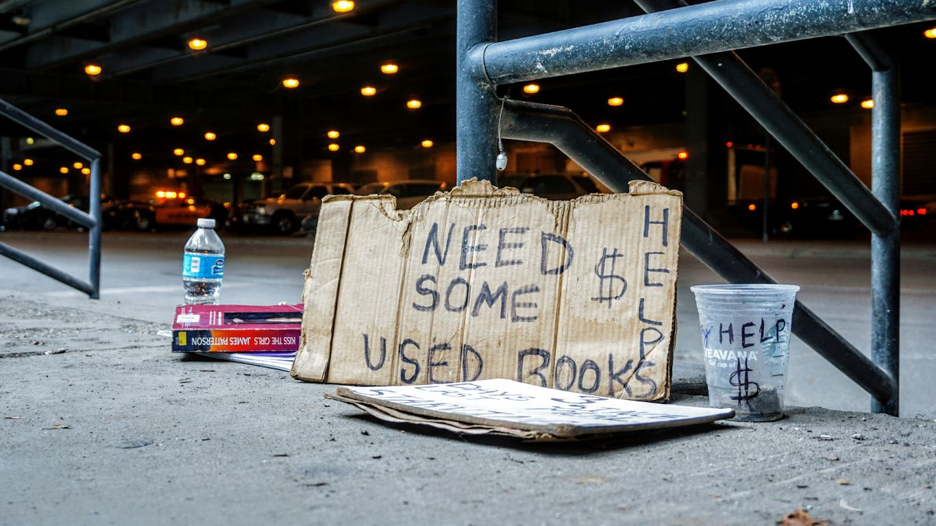 need some used books printer board near clear plastic cup leaning on black metal rail during night time