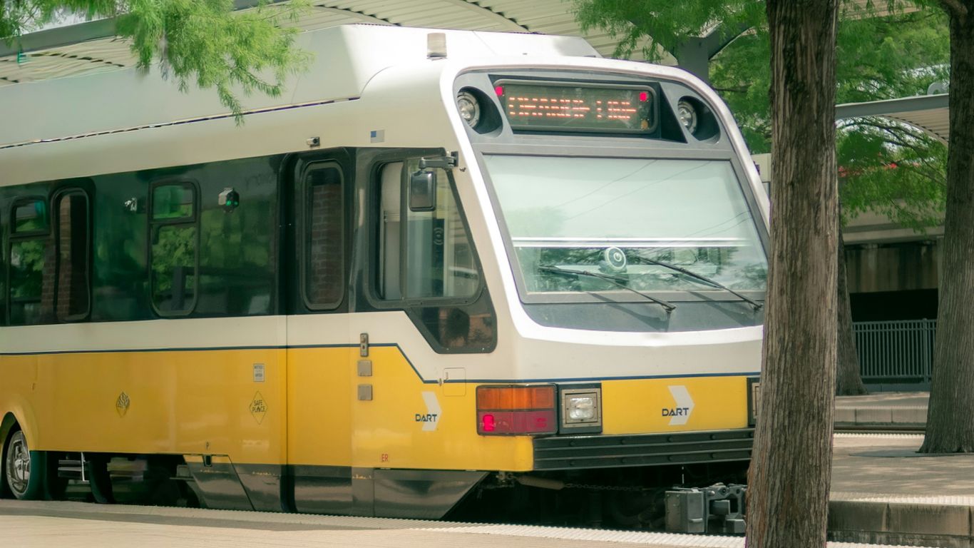 A modern train with yellow accents at a station.