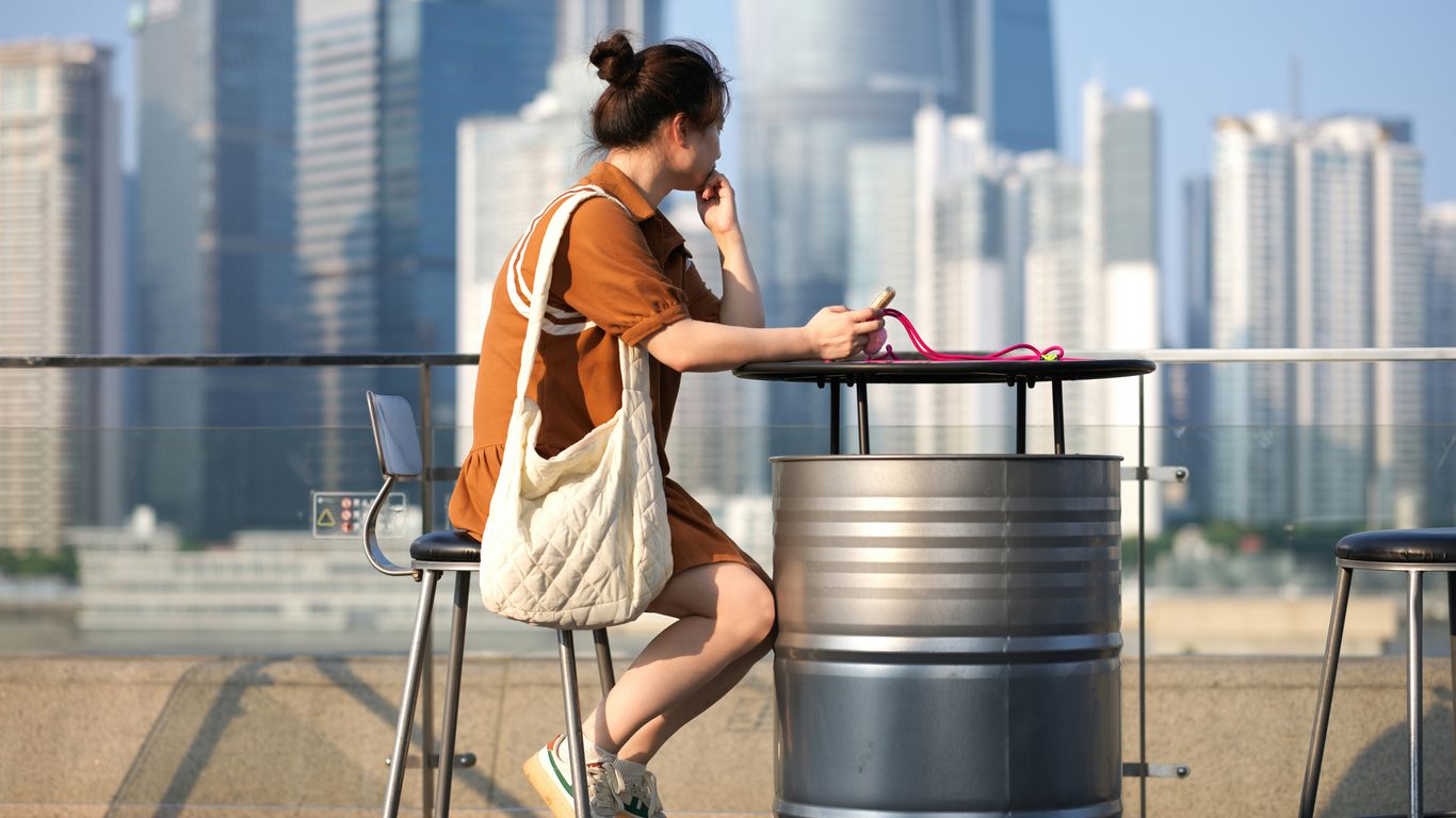A woman sitting at a table using a laptop computer