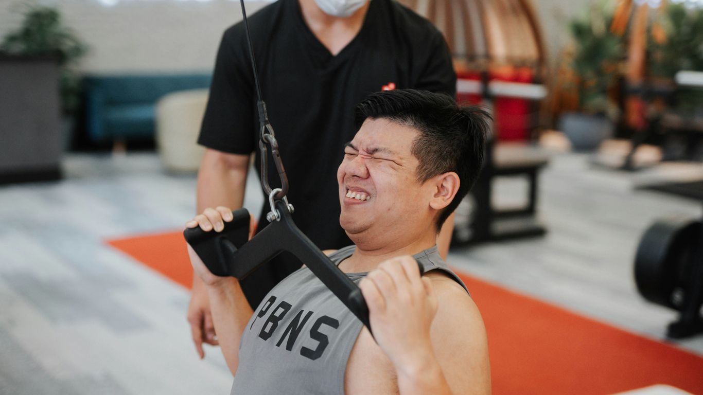 physical therapist assisting patient with spinal cord injury in rehabilitation gym