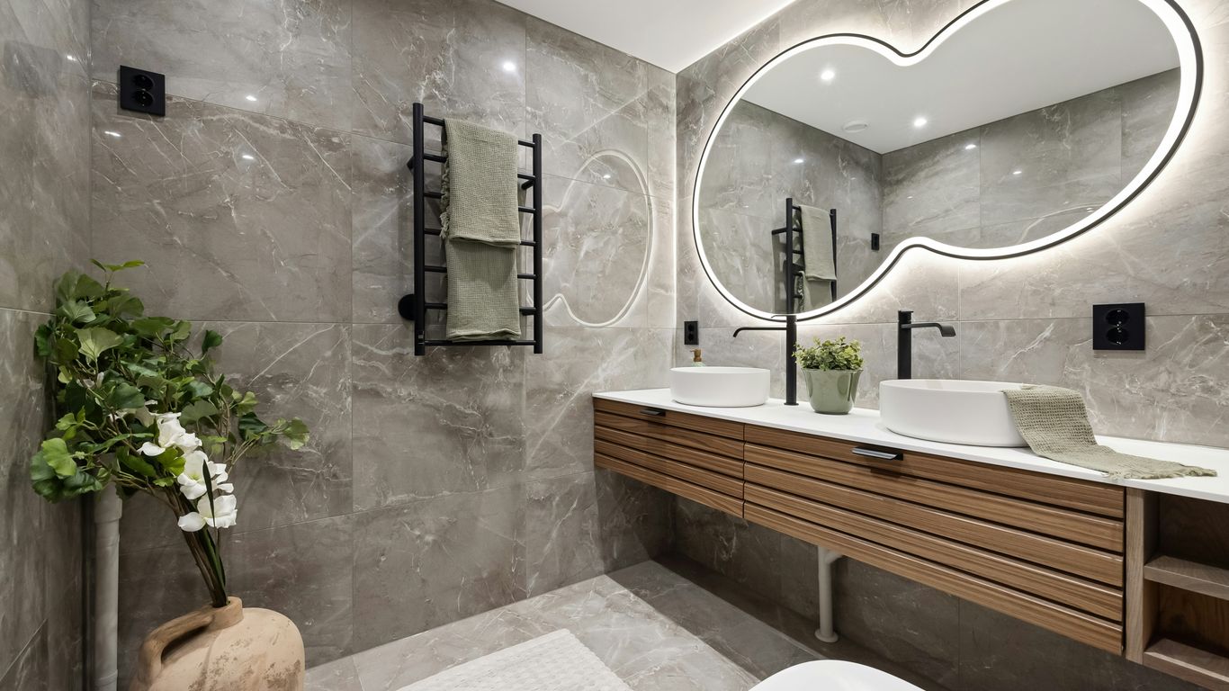 A bathroom with a large mirror above the sink