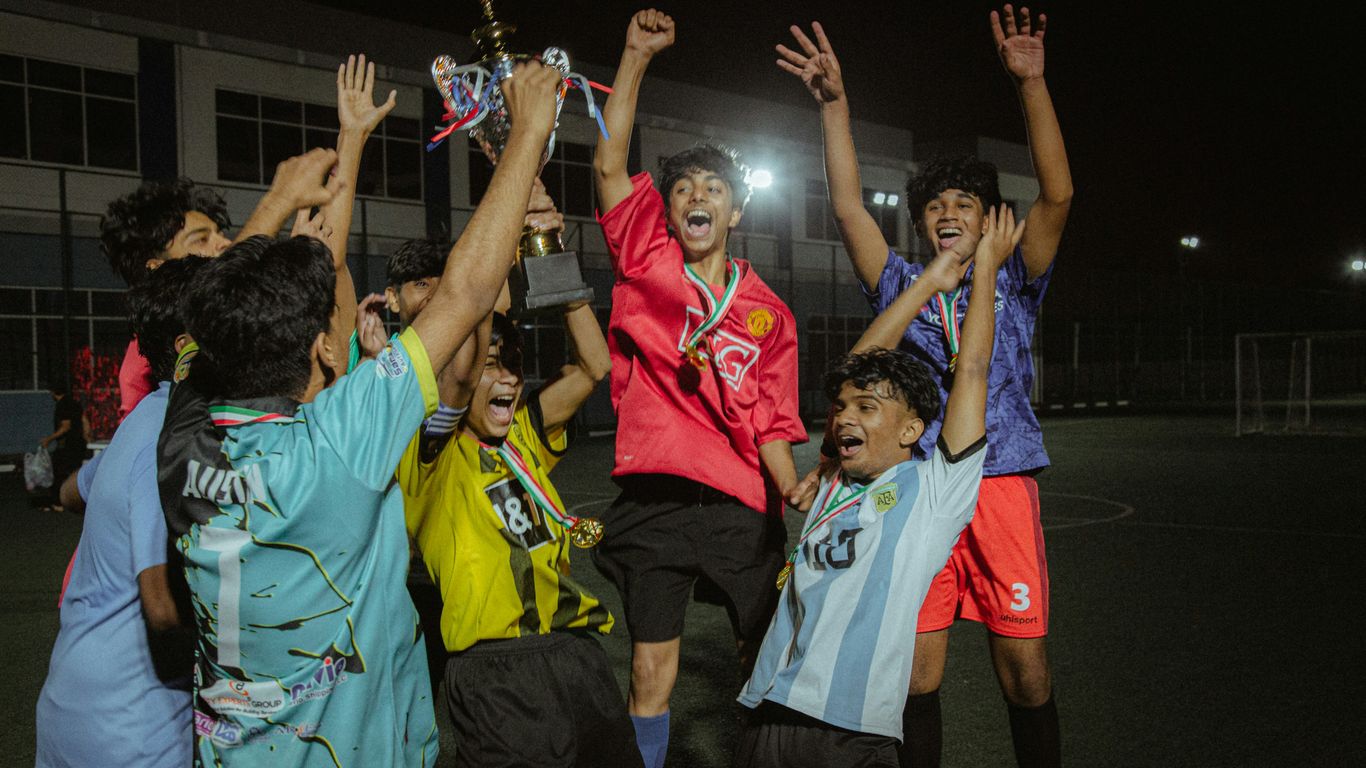 a group of young men standing on top of a soccer field