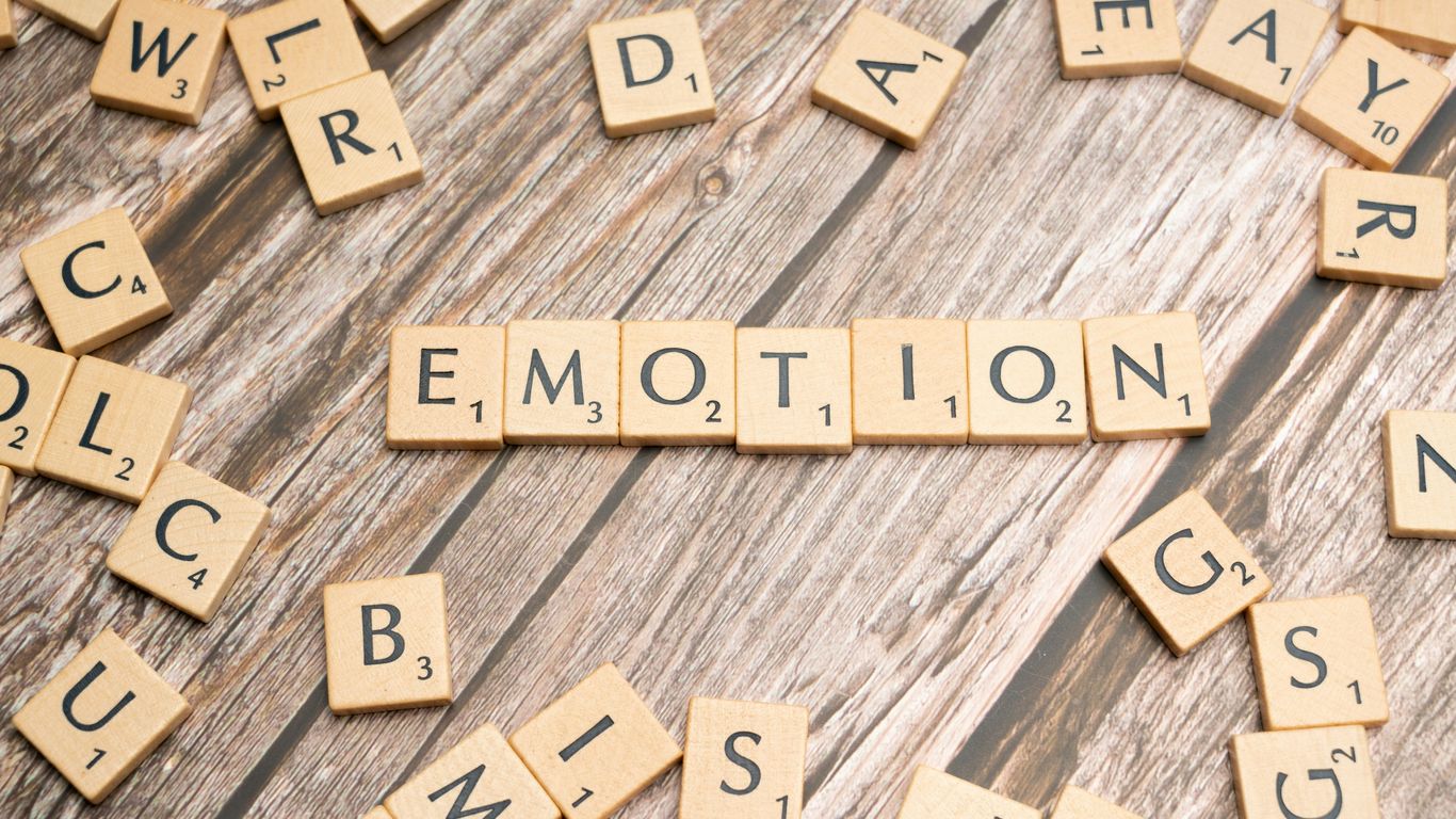 scrabble tiles spelling the word emotion on a wooden surface