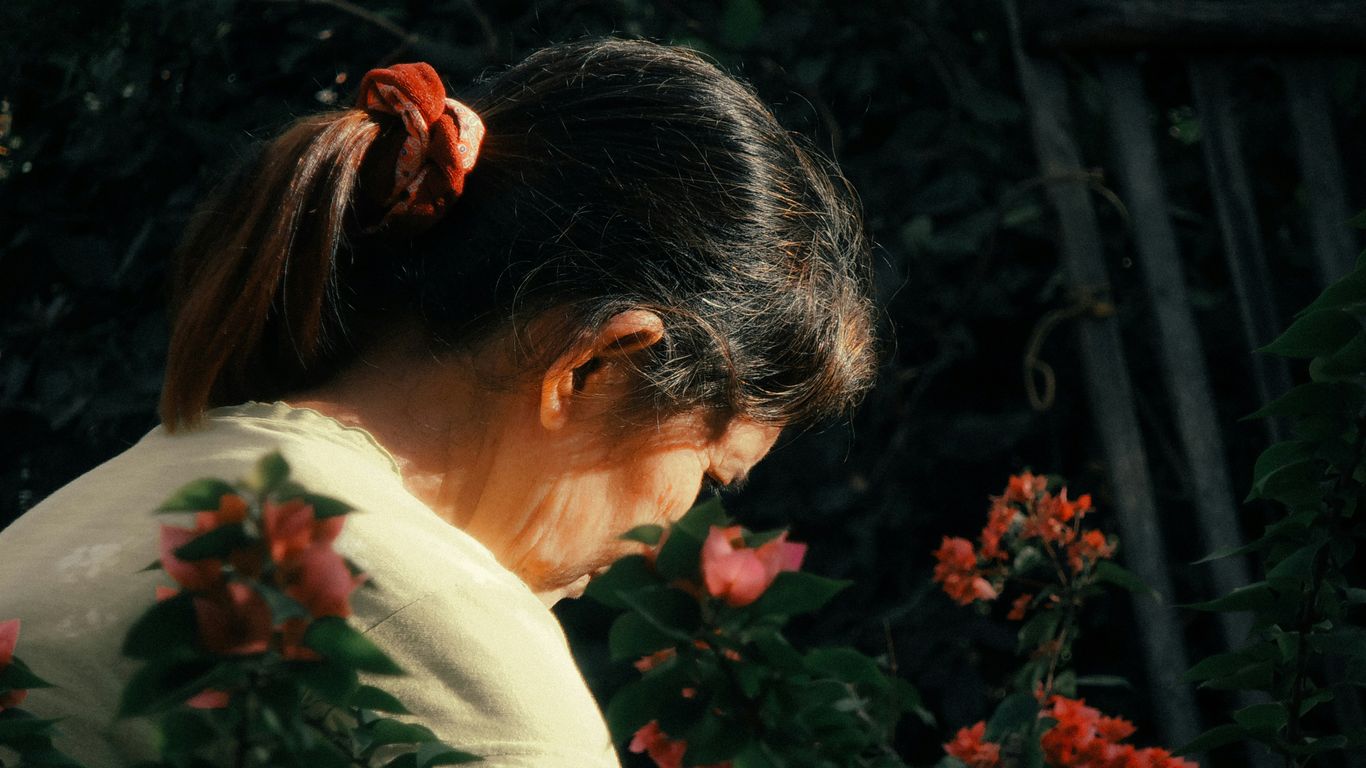 woman in white shirt standing near green plants during daytime