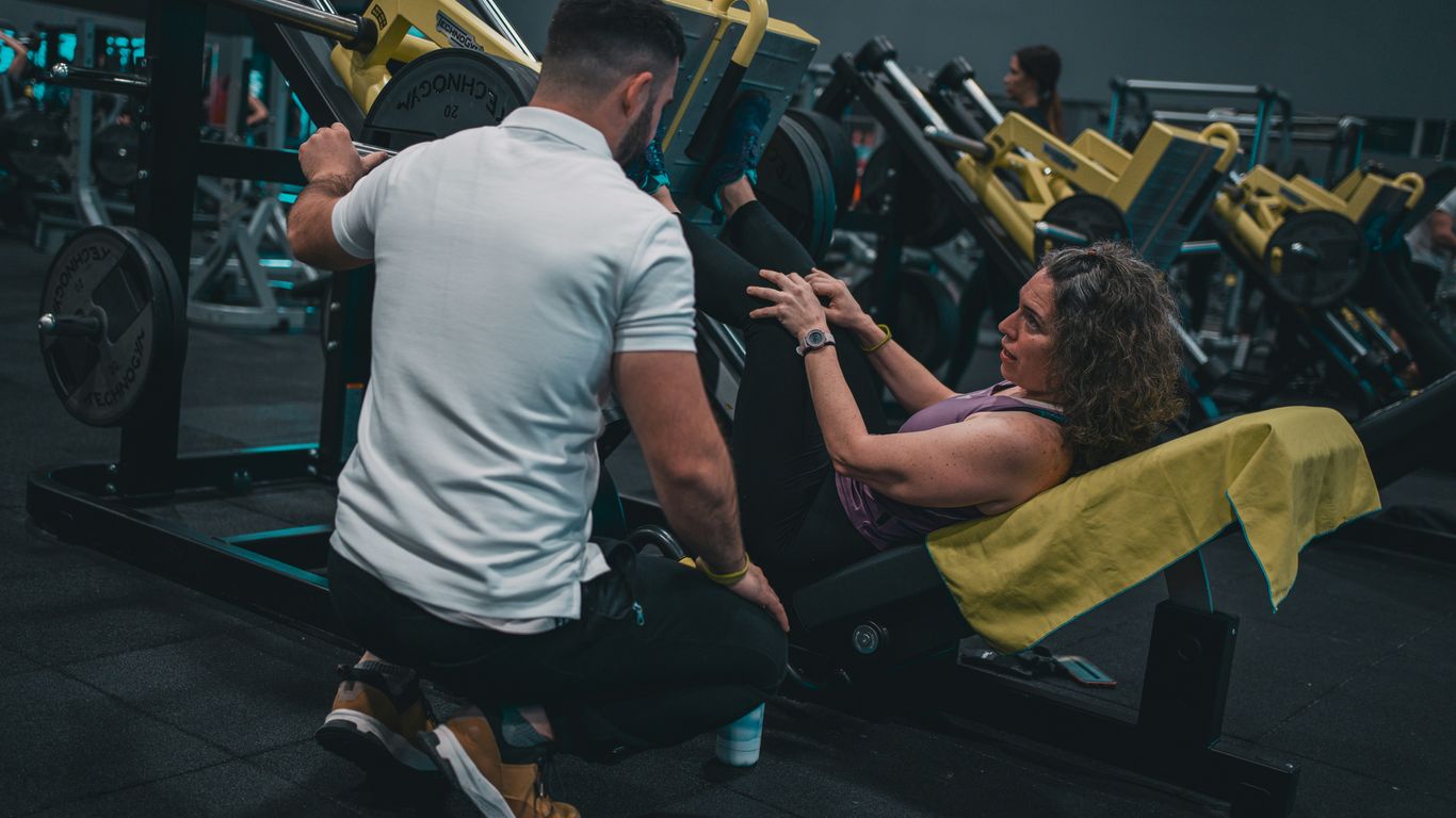 A man and a woman working out in a gym