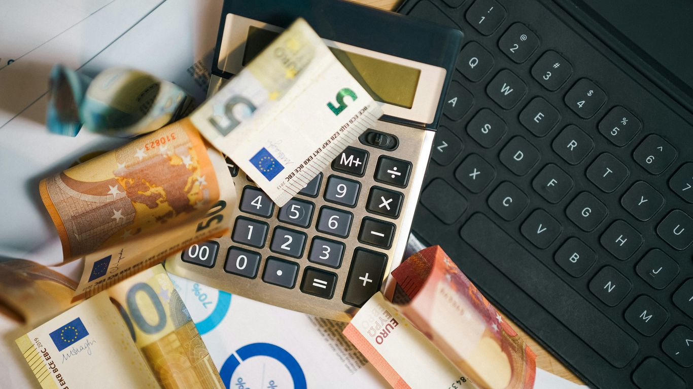 A calculator sitting on top of a pile of money
