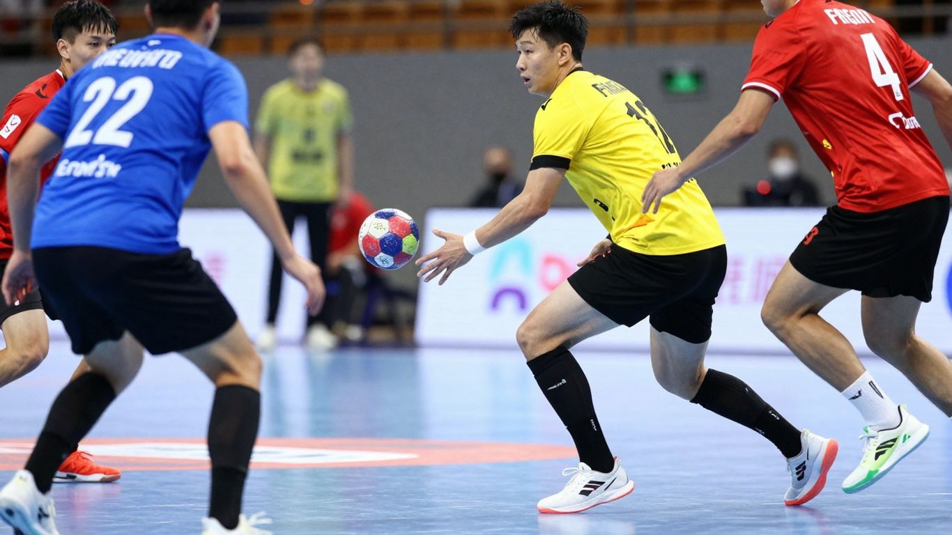 Jucători de handbal în acțiune cu mingea.