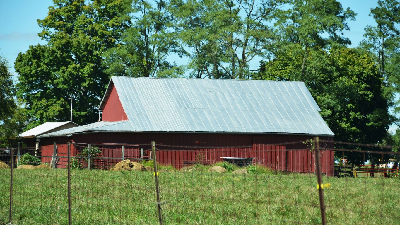 A red barn with a metal roof in a field