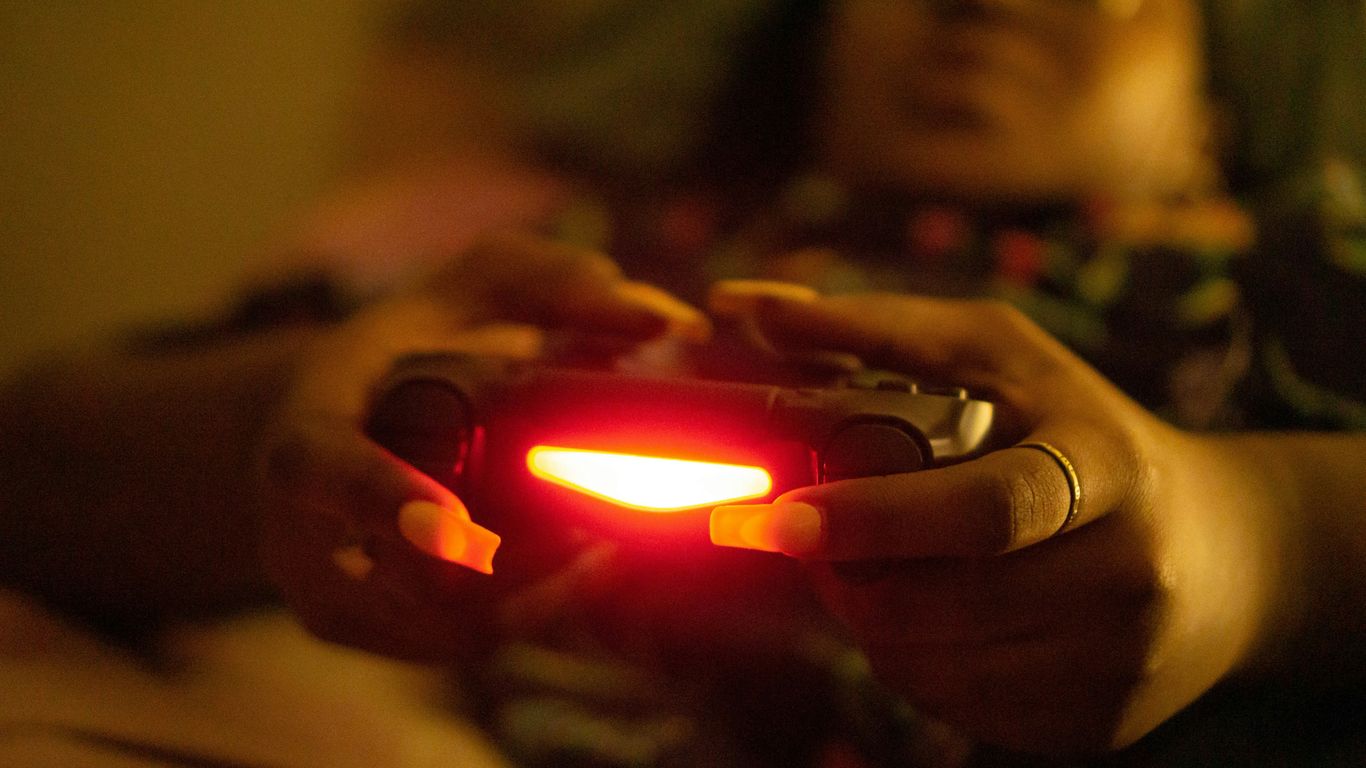 a close up of a person holding a game controller