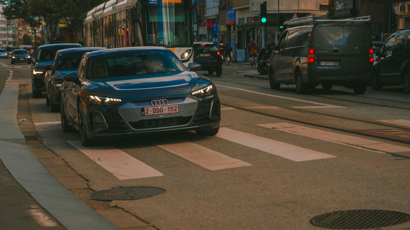 Cars are stopped at a crosswalk on a city street.