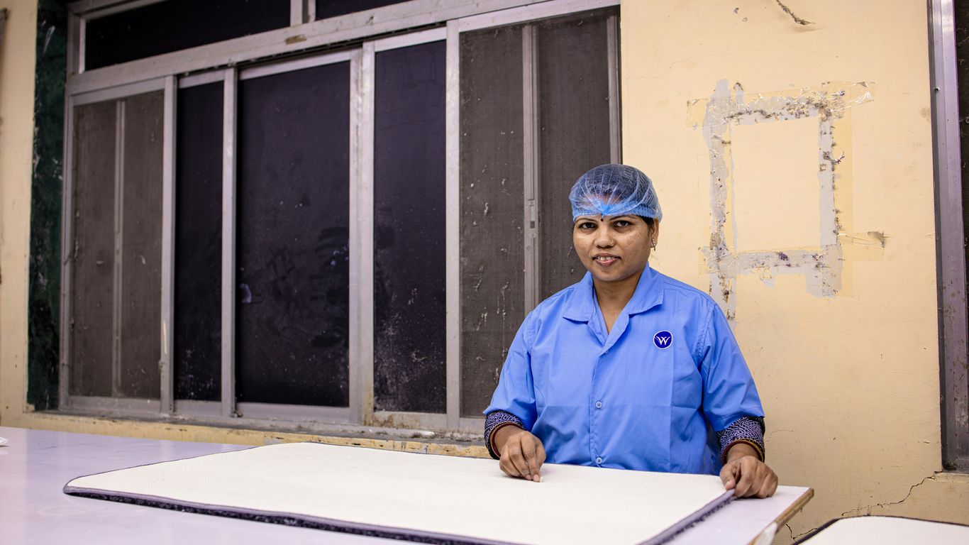 Woman in uniform stands behind a table.