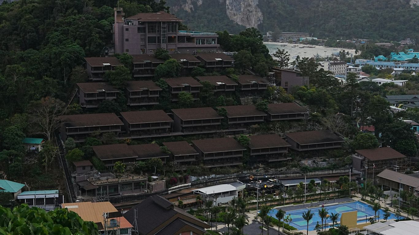Resort buildings on a steep, tree-covered hillside overlooking town.