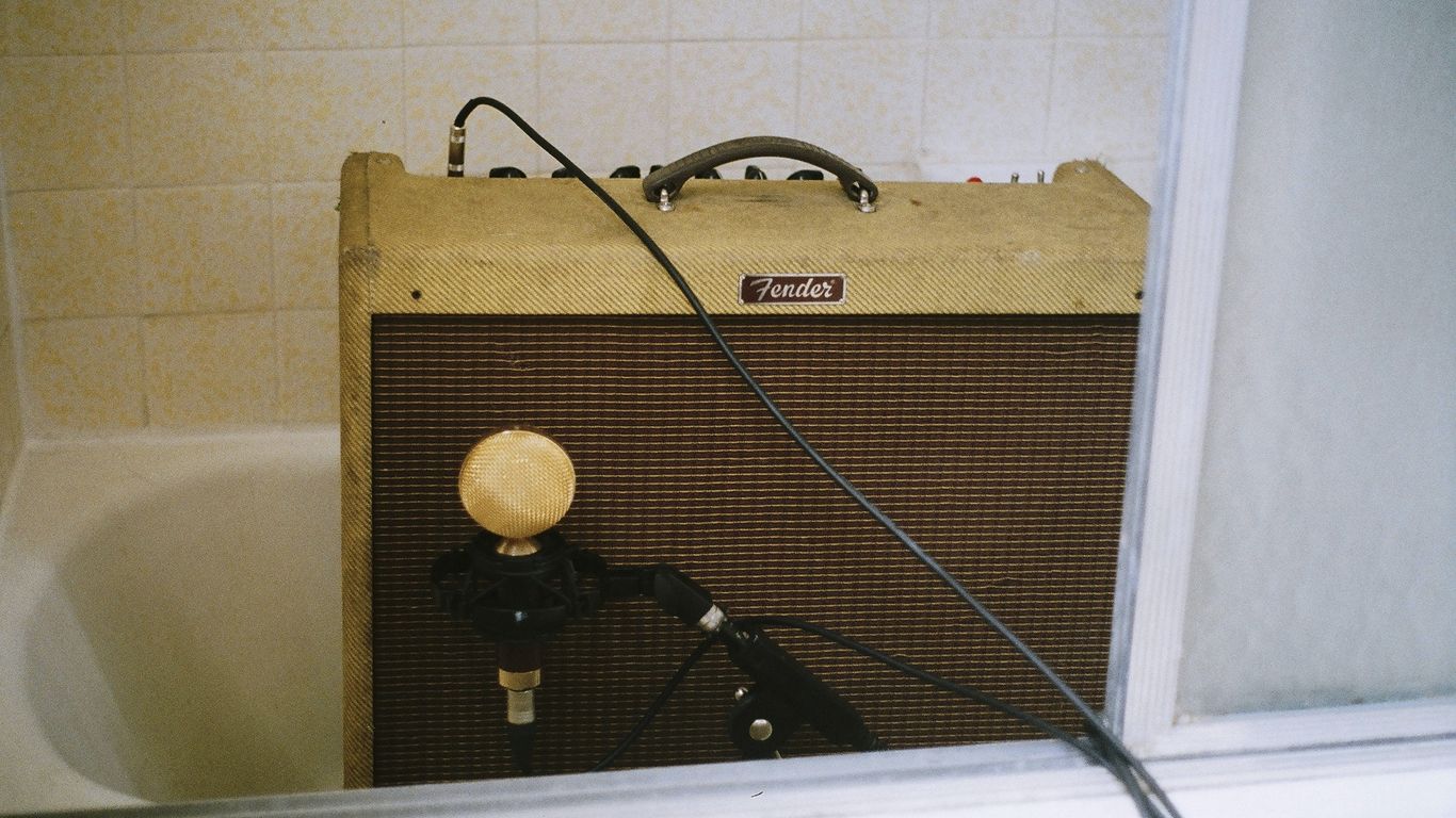 brown guitar amplifier on bath tub