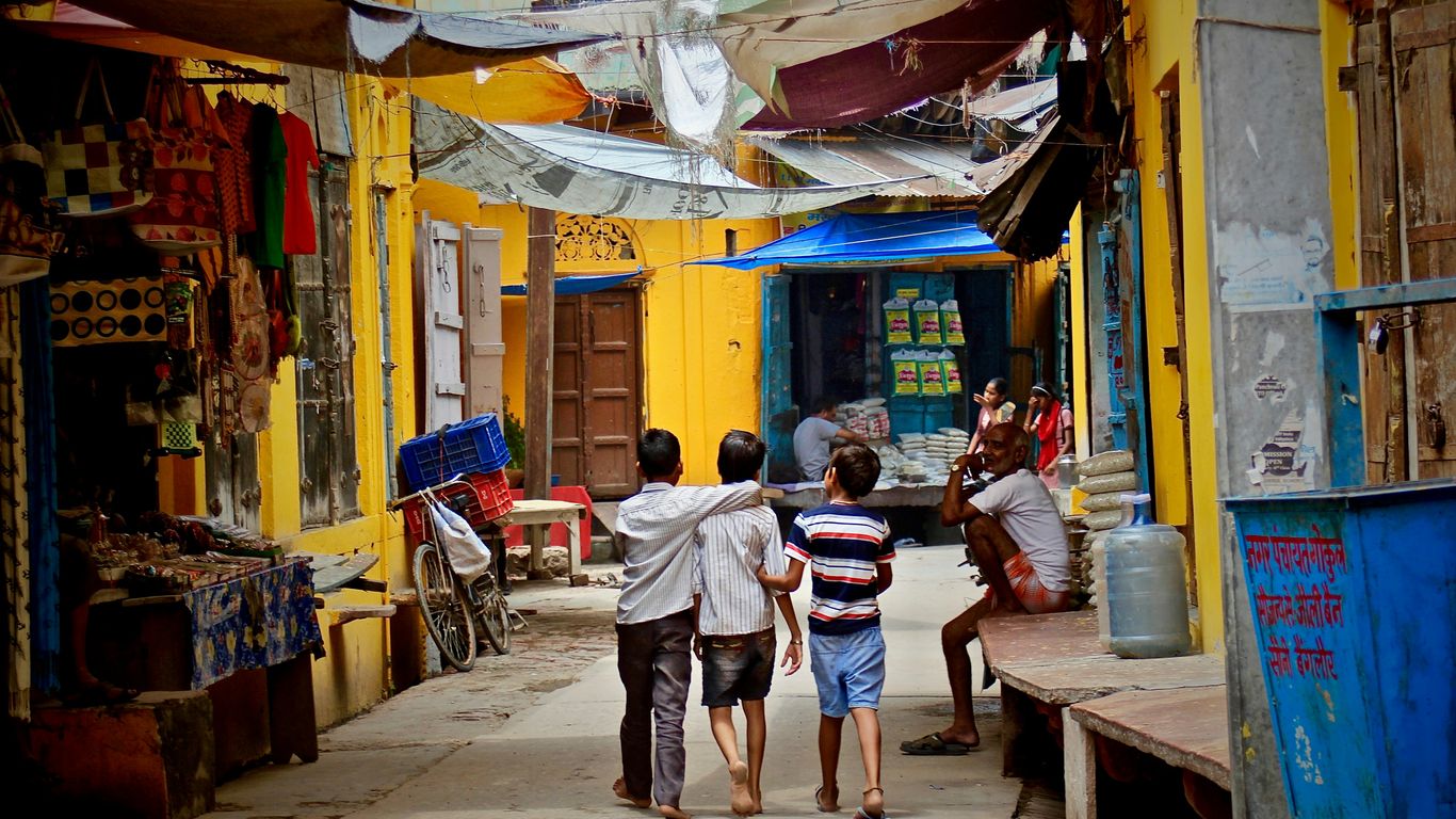 three boys walking between buildings at daytime